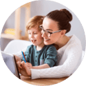 A smiling mom and her boy look at a computer